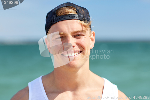 Image of close up of smiling young man on summer beach