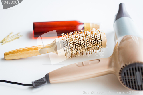 Image of hairdryer, brush, hot styling hair spray and pins