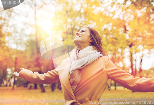 Image of beautiful happy young woman walking in autumn park