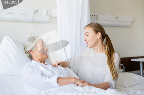 Image of daughter visiting senior mother at hospital