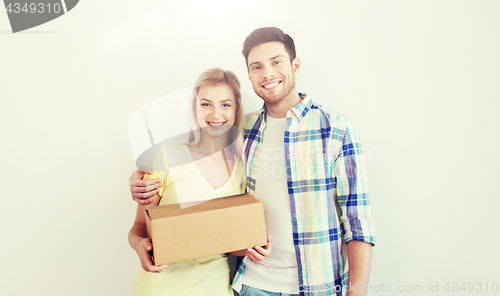 Image of smiling couple with box moving to new home