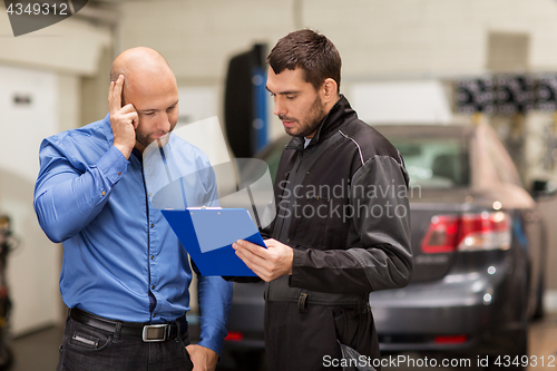 Image of auto mechanic and customer at car shop