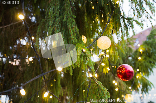 Image of close up of fir with christmas tree toys outdoors