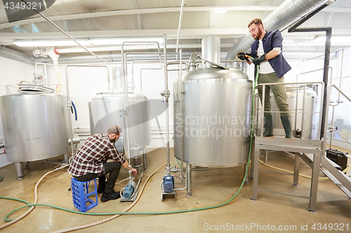 Image of men working at craft beer brewery kettles