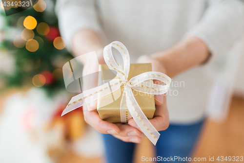 Image of close up of male hands with christmas gift