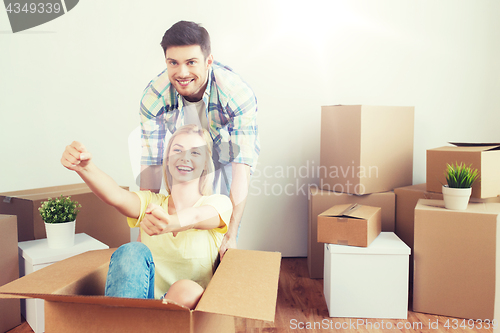 Image of happy couple having fun with boxes at new home