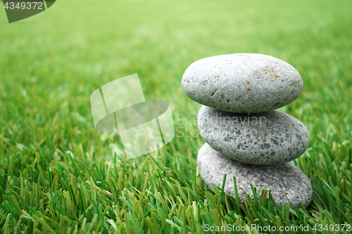 Image of Pebbles stacked up on grass