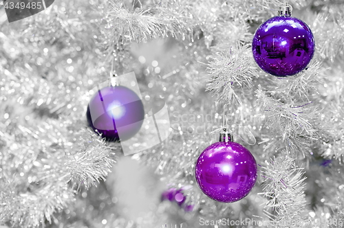 Image of Trendy colored violet or ultraviolet baubles on silver artificial christmas tree