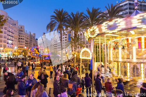 Image of Christmas fair with carousel on Modernisme Plaza of the City Hall of Valencia, Spain.