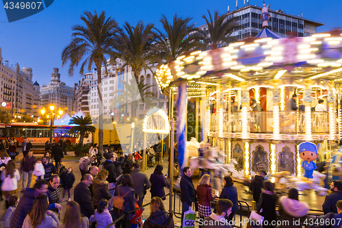 Image of Christmas fair with carousel on Modernisme Plaza of the City Hall of Valencia, Spain.