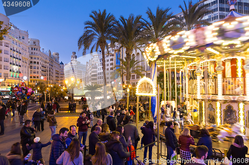 Image of Christmas fair with carousel on Modernisme Plaza of the City Hall of Valencia, Spain.