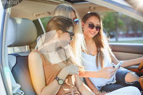 Image of The pretty european girls 25-30 years old in the car make photo on mobile phone