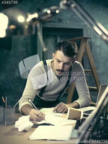 Image of Architect working on drawing table in office