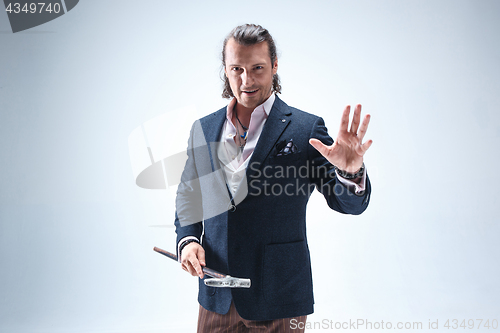 Image of The mature barded man in a suit holding cane.