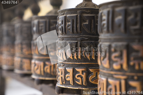 Image of Buddhist prayer wheels in row 