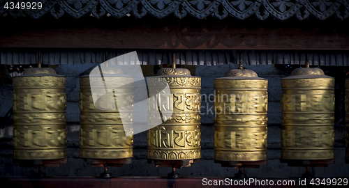 Image of Buddhist shiny prayer wheels rotating in motion