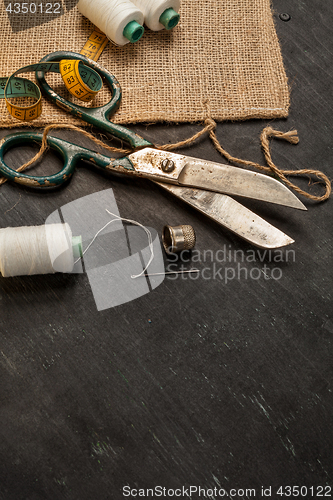 Image of Retro sewing accessories on black wooden background