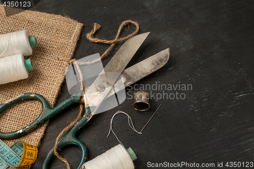 Image of Retro sewing accessories on black wooden background