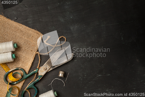 Image of Retro sewing accessories on black wooden background