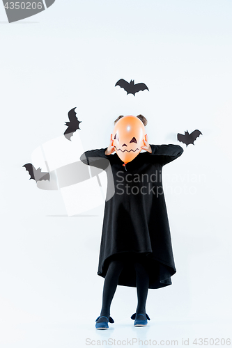 Image of Little girl witch in black dress over magical accessories. Halloween, the studio evening.