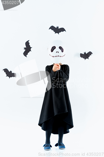 Image of Little girl witch in black dress over magical accessories. Halloween, the studio evening.