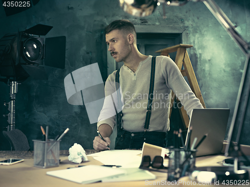 Image of Architect working on drawing table in office