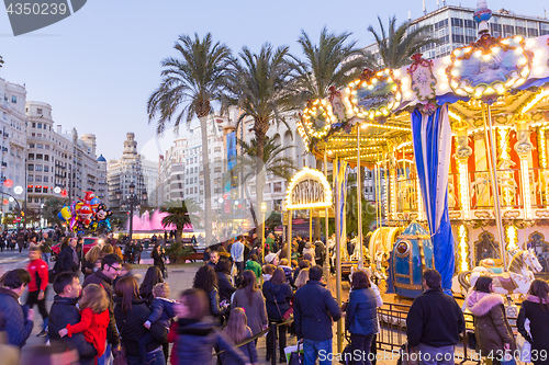 Image of Christmas fair with carousel on Modernisme Plaza of the City Hall of Valencia, Spain.