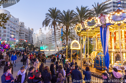 Image of Christmas fair with carousel on Modernisme Plaza of the City Hall of Valencia, Spain.