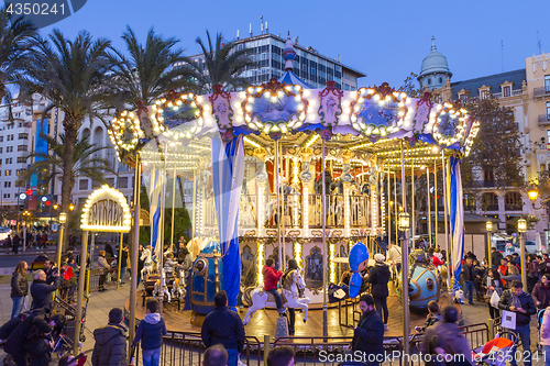 Image of Christmas fair with carousel on Modernisme Plaza of the City Hall of Valencia, Spain.