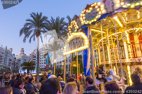 Image of Christmas fair with carousel on Modernisme Plaza of the City Hall of Valencia, Spain.