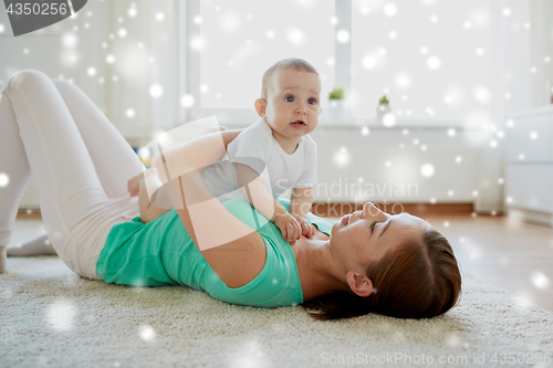 Image of happy mother playing with baby at home