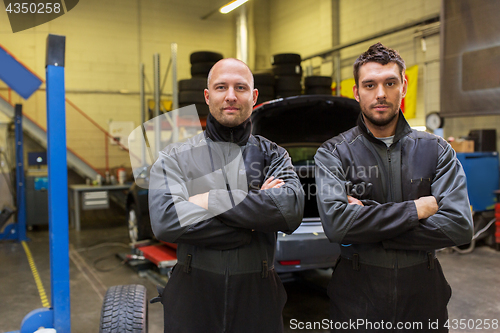 Image of auto mechanics or tire changers at car shop