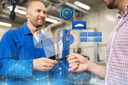 Image of auto mechanic giving car key to man at workshop