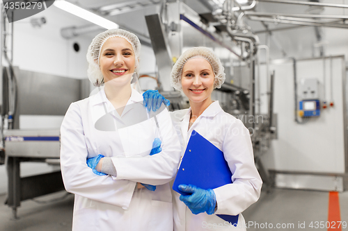 Image of happy women technologists at ice cream factory