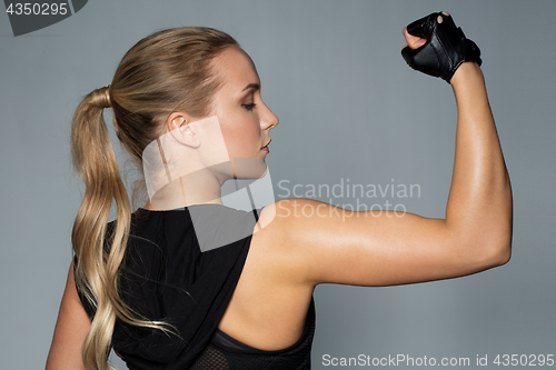 Image of close up of woman posing and showing biceps in gym