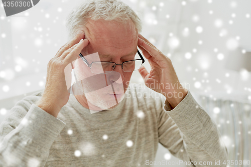 Image of senior man suffering from headache at home