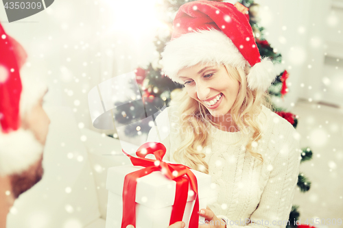 Image of happy couple at home with christmas gift box