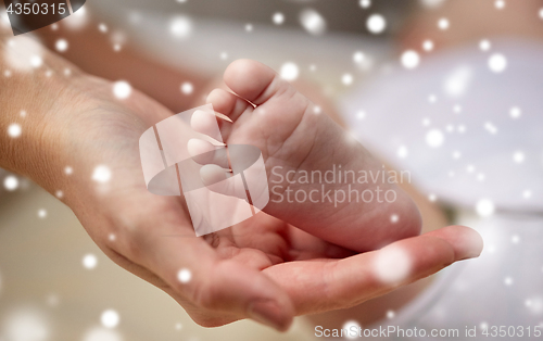 Image of close up of newborn baby feet in mother hands