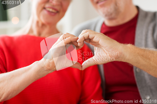 Image of close up of senior couple showing hand heart sign