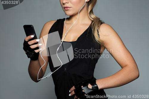 Image of sportswoman with smartphone and earphones