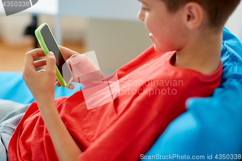 Image of happy smiling boy with smartphone at home