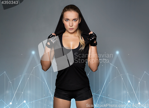 Image of young woman in black sportswear posing