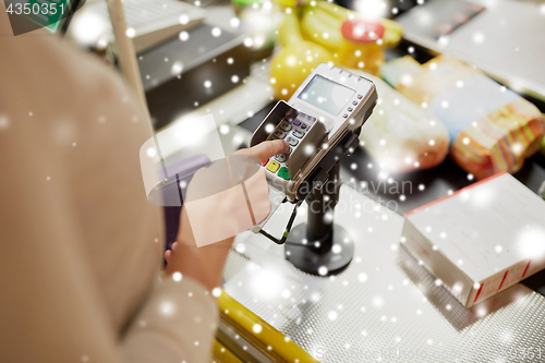 Image of woman entering pin code at store cash register