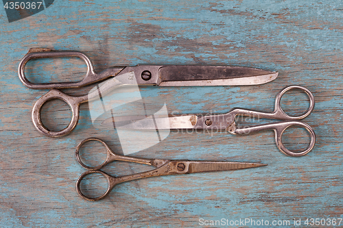 Image of A set of vintage scissors on blue wooden background