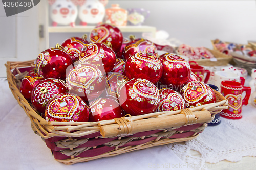 Image of Red Christmas balls in wicker basket, hand painted with traditio