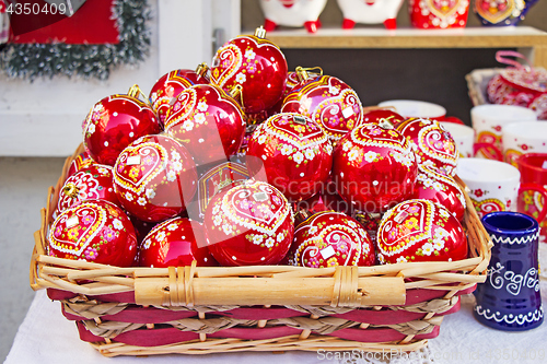 Image of Red Christmas balls in wicker basket, hand painted with traditio