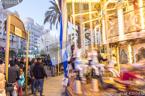 Image of Christmas fair with carousel on Modernisme Plaza of the City Hall of Valencia, Spain.