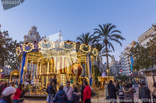 Image of Christmas fair with carousel on Modernisme Plaza of the City Hall of Valencia, Spain.