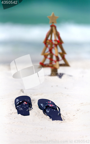 Image of Australia flag thongs on a white sandy beach at Christmas