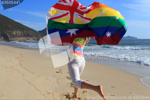 Image of Marriage Equality  Joyous woman running along the beach with a r